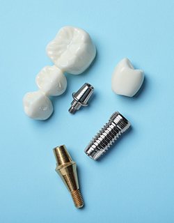Dental implant and dental bridge parts set against a blue background